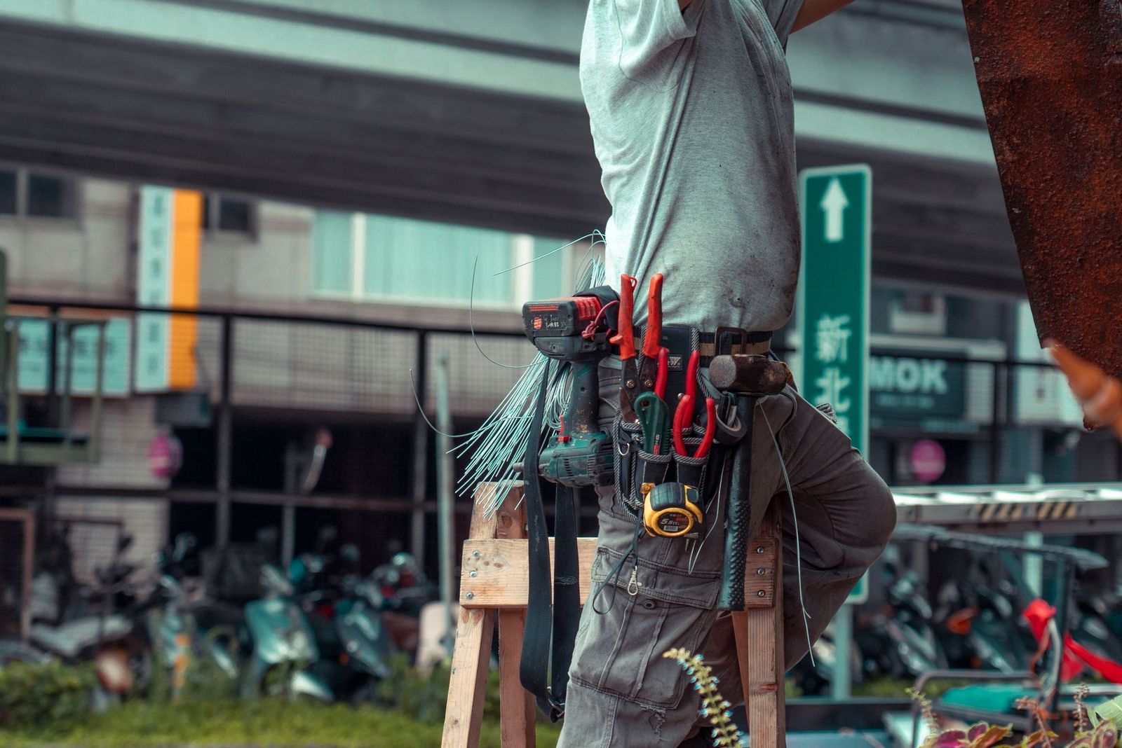 Handwerker mit Werkzeuggürtel auf der Leiter